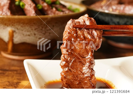 たっぷりのタレにつけた牛ハラミの焼肉 121391684