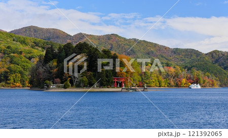 秋の信州信濃町 青い野尻湖の弁天島（宇賀神社）に白い遊覧船回遊 121392065