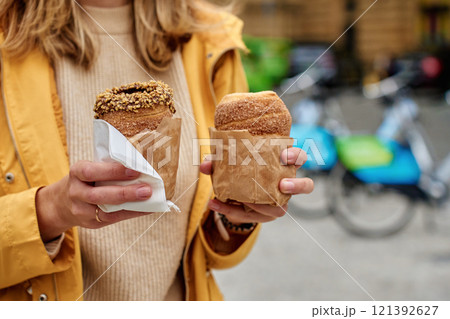 Woman holding two traditional chimney cakes at street of Prague, Czech Republic 121392627