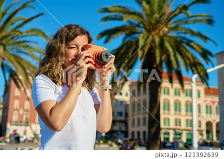Young Woman Taking Photos in Coastal Town 121392639
