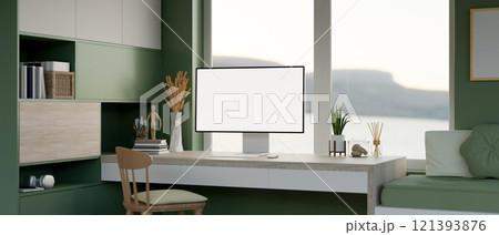 A modern green apartment featuring a computer on a minimalist wooden desk against the window. 121393876