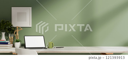 A digital tablet with a white screen mockup and decor on a table against a green wall in a room. 121393913