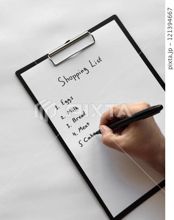 Hand writing shopping list on clipboard with eggs, milk, bread, meat, cakes items Hand writing shopping list on clipboard with eggs, milk, bread, meat, cakes items 121394667
