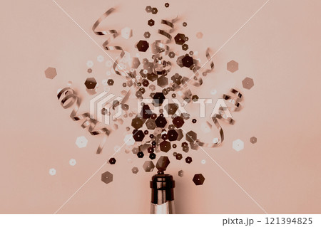 Christmas composition with champagne bottle and sparkling confetti, mocha mousse tinting Christmas composition with champagne bottle and sparkling confetti, mocha mousse tinting 121394825