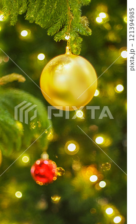 Christmas Decorations: Close-Up of Red and Green Baubles Hanging on a Tree for Holiday Promotions, Greeting Cards, and Seasonal Events 121394985
