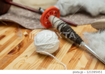 Handcrafted wool yarn and spindle on wooden table Handcrafted wool yarn and spindle on wooden table 121395451