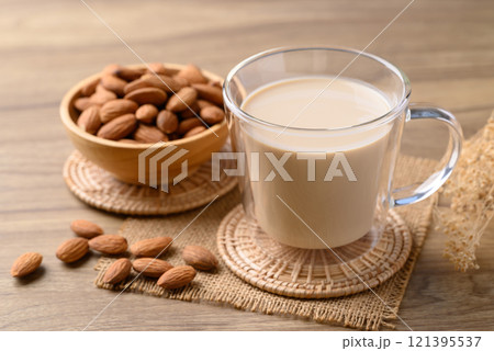 Almond milk in cup glass on wooden table, Alternative milk made from plant, non dairy Almond milk in cup glass on wooden table, Alternative milk made from plant, non dairy 121395537