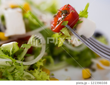 Tomatoes onion mozzarella on fork 121398108
