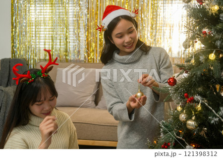 Two friends decorated Christmas tree at home. 121398312