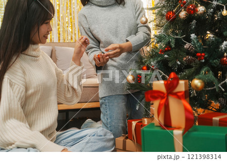 Two friends decorated Christmas tree at home. 121398314