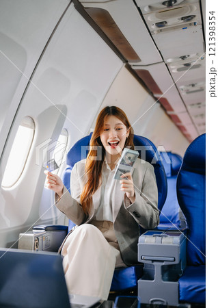 Young Asian executive excels in first class, multitasking with digital tablet, laptop and smartphone. for finance, travel, and lifestyle Young Asian executive excels in first class, multitasking with digital tablet, laptop and smartphone. for finance, travel, and lifestyle 121398354