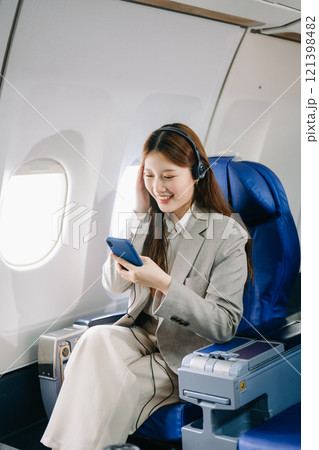 Young Asian executive excels in first class, multitasking with digital tablet, laptop and smartphone. for finance, travel, and lifestyle 121398482