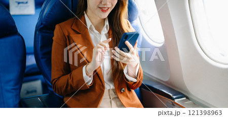Portrait of a successful Asian businesswoman or entrepreneur in a formal suit on an airplane sitting in business class Portrait of a successful Asian businesswoman or entrepreneur in a formal suit on an airplane sitting in business class 121398963