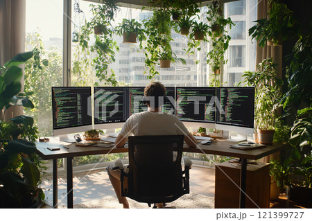Programmer working with computer at table. Screens show layered code structures and systems analysis. AI Generated. 121399727