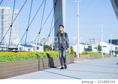 屋外を歩く男性 121400154