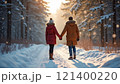 Couple holding hands on snowy forest path at sunset. 121400220