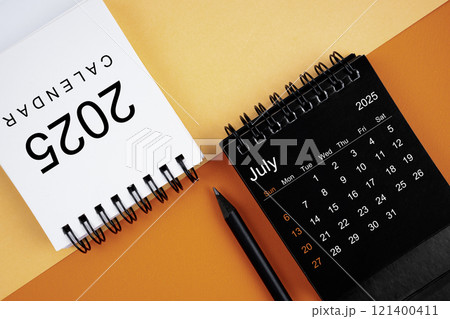 April 2025 desk calendar black and white color with pencil on orange background. 121400411