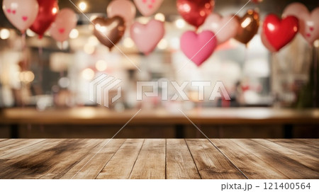 Empty wooden tabletop on blurred background of cafe decorated with heart balloons for Valentine's Day 121400564