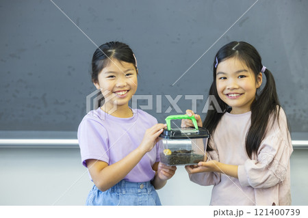 虫かごを観察する小学生　　　 121400739
