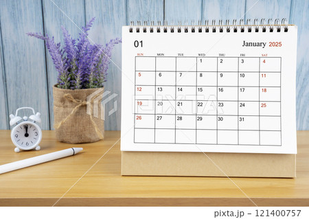 January Monthly desk calendar for 2025 year and alarm clock. 121400757