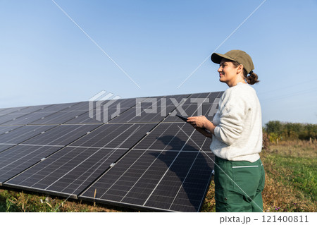 Female farmer with digital tablet on a modern farm using solar panels Female farmer with digital tablet on a modern farm using solar panels 121400811