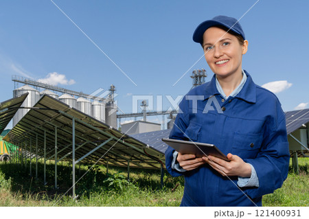 Female farmer with digital tablet on a modern farm using solar panels. Female farmer with digital tablet on a modern farm using solar panels. 121400931