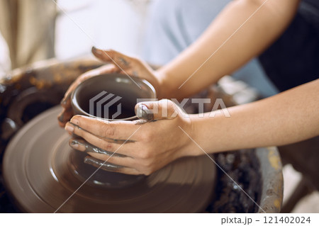Hands of craftsman artist working on pottery wheel. Hands of craftsman artist working on pottery wheel. 121402024