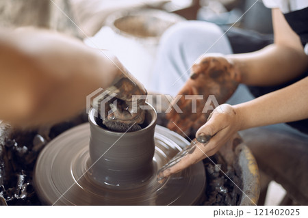 Hands of craftsman artist working on pottery wheel. Hands of craftsman artist working on pottery wheel. 121402025