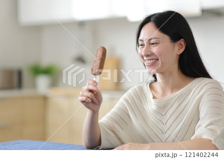 Happy asian woman looking at chocolate ice cream ready to eat 121402244