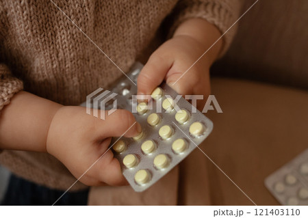The child took out pills, the girl is playing with medical medicine, a one-year-old child can eat pills and not wake up, poison. Danger in the house, medicines are dangerous for young children. 121403110