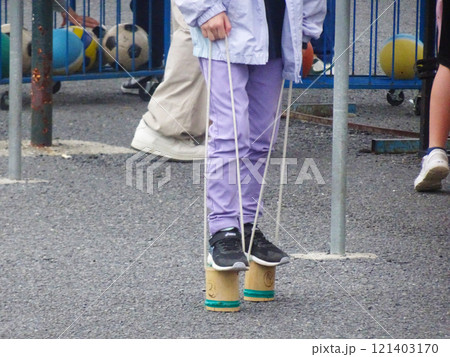 竹ポックリで遊ぶ子供 121403170