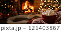 Red mug full of marshmallows warming near fireplace and christmas tree lights 121403867