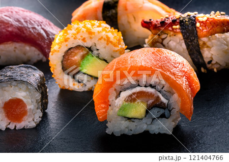 Sushi rolls on a black background. Uramaki with salmon and avocado 121404766