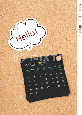 March 2025 Black calendar page and Hello text with thumbtack on board. 121404883
