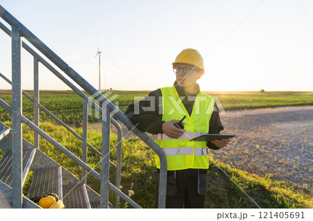 Engineer with digital tablet controls wind turbines 121405691