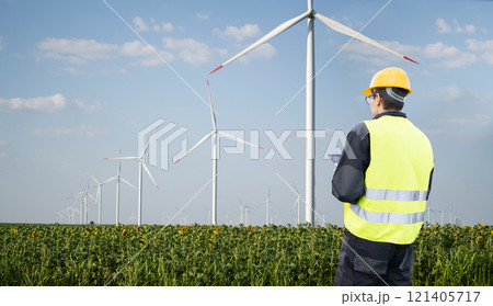Engineer with tablet computer on a background of wind turbine 121405717