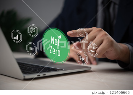 Businessman hand selecting a glowing net zero icon next to environmental symbols. 121406666