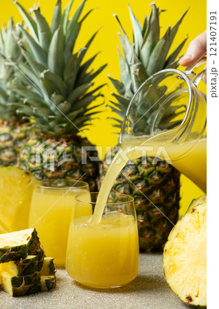 Pineapple juice is poured into a glass, a healthy vitamin drink. 121407191