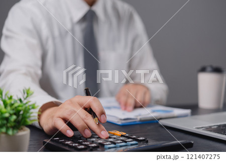 Businessman using calculator bookkeeping payroll and budget tax. Business document finance accounting investment 121407275