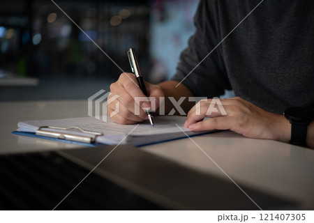man hands with pen writing on notebook in the office.learning, education and work.writes goals, plans, make to do and wish list on desk. 121407305