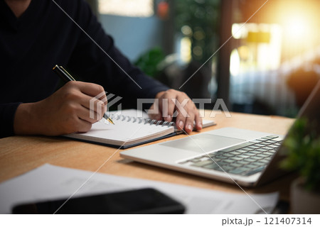 Person taking notes with pen on notebook, planning, organization, or learning. Ideal for business, education, and productivity visuals. Person taking notes with pen on notebook, planning, organization, or learning. Ideal for business, education, and productivity visuals. 121407314
