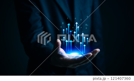 A hand holding glowing upward arrows, symbolizing growth, success, and progress in business and technology A hand holding glowing upward arrows, symbolizing growth, success, and progress in business and technology 121407360