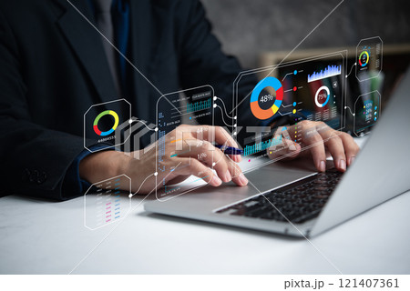 A person operates a laptop displaying digital analytics charts and graphs. A person operates a laptop displaying digital analytics charts and graphs. 121407361