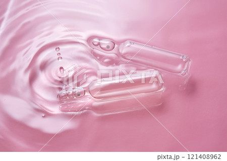 Ampoules in water on a pink background. Ampoules in water on a pink background. 121408962