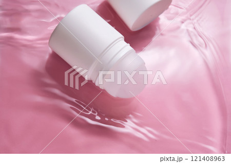 Roll-on deodorant on a pink background in water. Roll-on deodorant on a pink background in water. 121408963