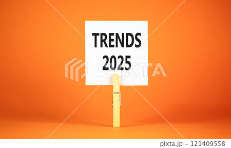 Planning trends 2025 new year symbol. Concept words Trends 2025 on beautiful white paper on wooden clothespin. Beautiful orange background. Business trends 2025 new year concept. Copy space. 121409558