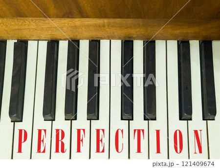Perfection symbol. Concept word Perfection on beautiful keys of the old retro piano. Beautiful piano-keys background. Black and white keys of the piano. Business perfection concept. Copy space. 121409674
