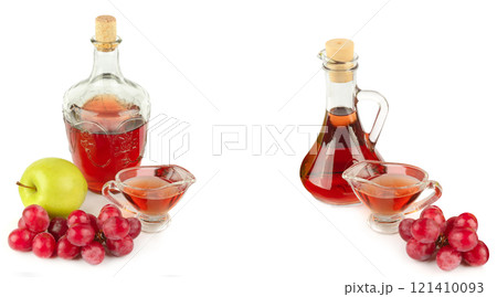 Apple vinegar and wine in glass bottle and ripe apples and grapes isolated on white background. There is free space for text. Collage. Apple vinegar and wine in glass bottle and ripe apples and grapes isolated on white background. There is free space for text. Collage. 121410093