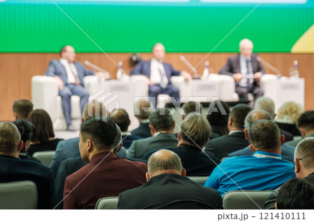 Business conference with audience and panelists on stage engaging in discussions 121410111