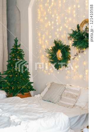 Christmas tree and wreath in bedroom, holiday decor and warm lighting during winter months 121410588